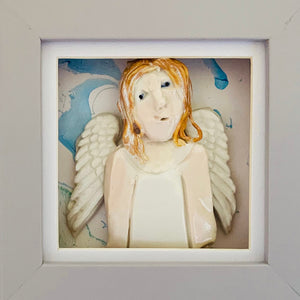 Guardian Angel 6 by Heather Tobias is a porcelain and underglazed celestial being on a marbled acrylic background in a light grey frame.