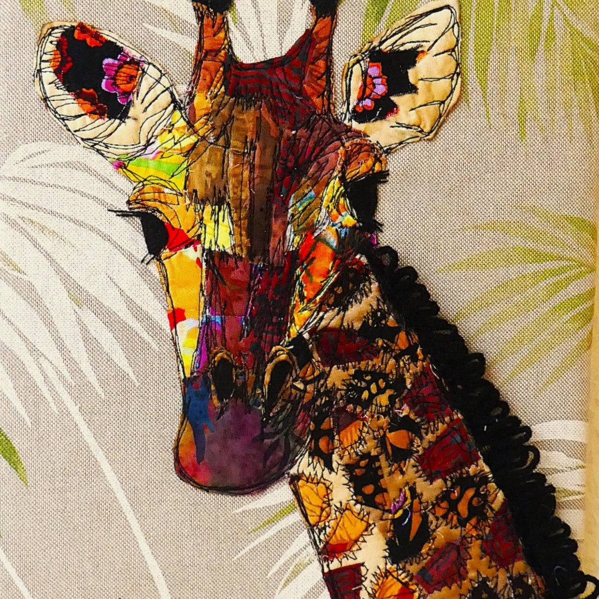 This giraffee is created usin collaged fabrics that are then stitched.