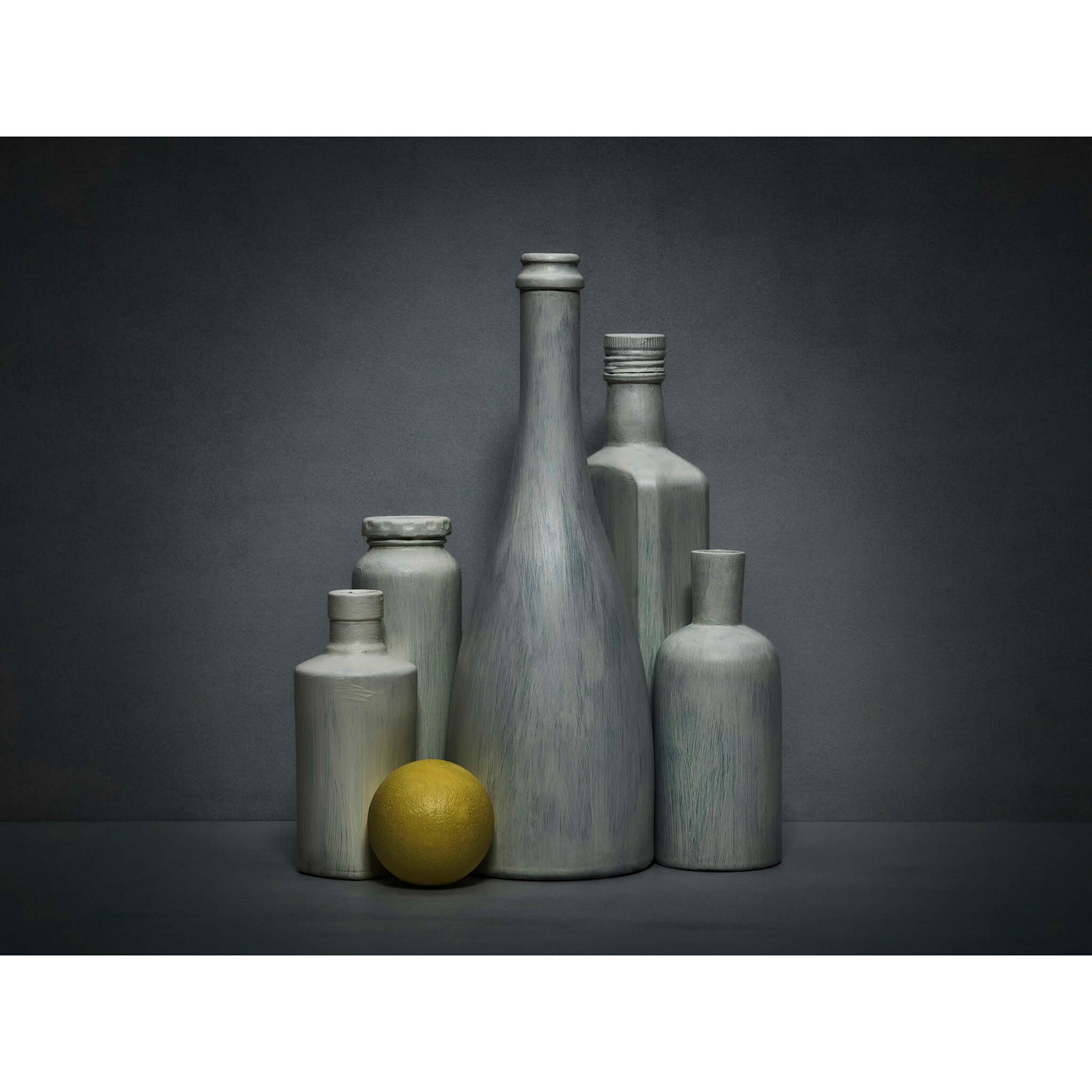 Grey bottles and yellow citrus fruit on a dark grey background