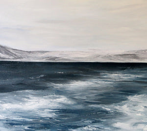 Seascape with water and mountains on a cloudy day