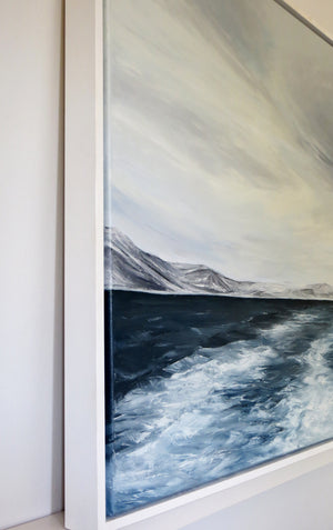 Framed artwork of a mountain landscape with a body of water.