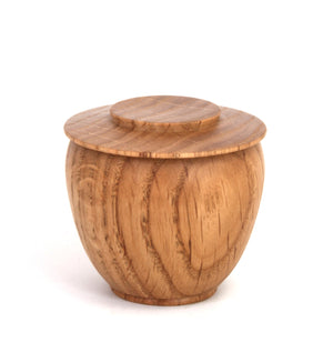 A small round wooden storage jar with a matching lid, featuring a warm honey-brown wood grain finish, photographed on a clean white background.
