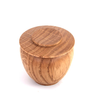 A small round wooden storage jar with a lid, featuring a natural warm brown wood grain pattern, photographed on a clean white background.
