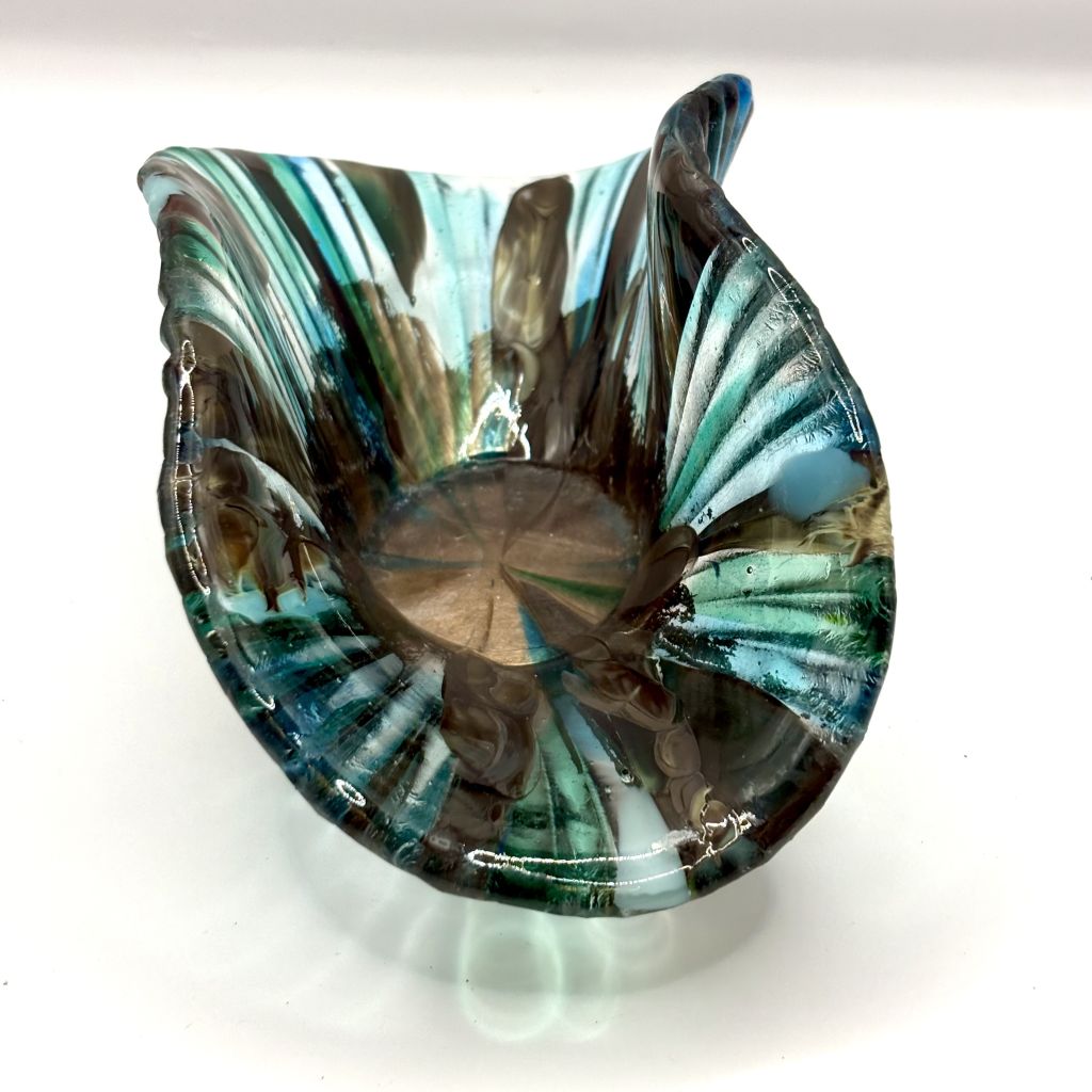 A small shell shaped fused ornament in blue and bronze hues by Agata Henderson