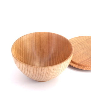 A small round wooden bowl with a matching wooden lid, shown on a clean white background.