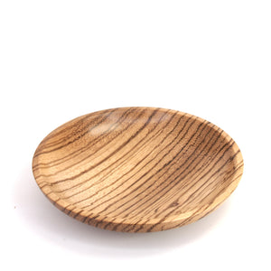 A small oval wooden serving plate with a prominent dark grain pattern on a light tan wood base, photographed on a clean white background.