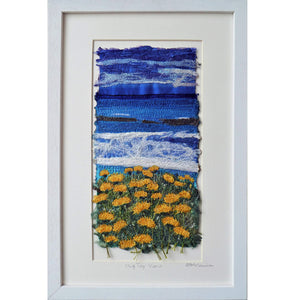 Cliff Top View by Diana Mckinnon embroidery artist comprising blue sky, ocean and yellow coastal flowers in white frame
