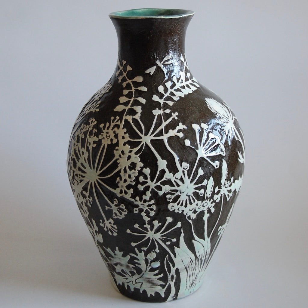 Black stoneware vase decorated with white sgraffito carvings of wild flowers and grasses by Jonquil Cook