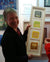 gill hickman  textural artist holding her abstract artwork the four seasons vertical made with special papers and gold leaf