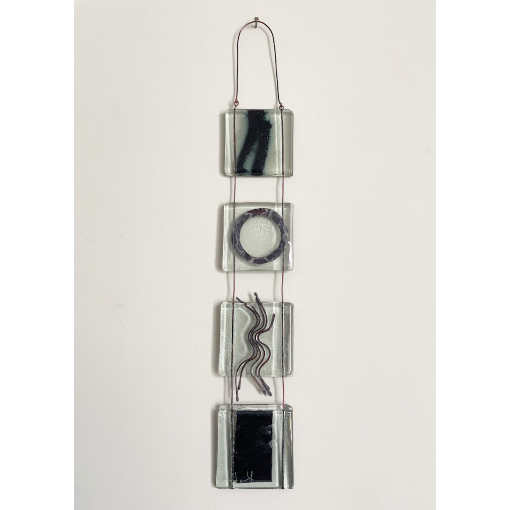 hand made small kiln formed fused glass icon hanging with abstract shapes and patterns made from metal inclusions in four squares joined together by wire trapped inside the glass by london based glass artist eryka isaak
