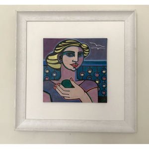 Glazed earthenware ceramic hand painted tile of a woman with painted nails holding a piece of sea glass by artist Linda Samson on wall