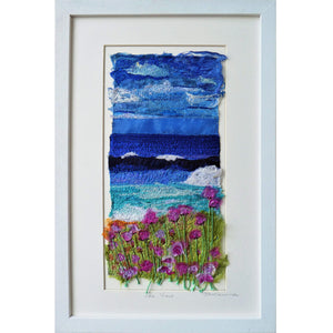 Sea View by Diana Mckinnon silk embroidery artist comprising blue sky, ocean and pink coastal flowers in white frame