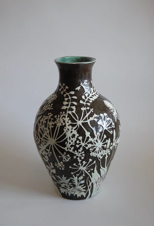 Black stoneware vase decorated with white sgraffito carvings of wild flowers and grasses by Jonquil Cook